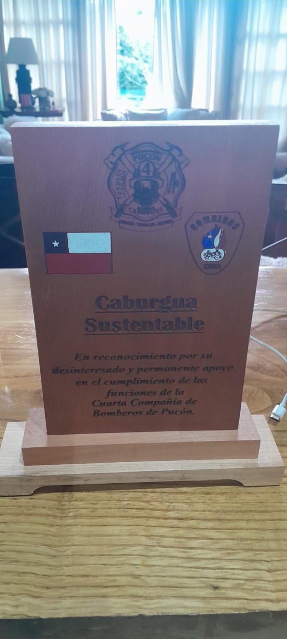 Galvano de reconocimiento en madera entregado por la Cuarta Compañía de Bomberos de Pucón a la Fundación Caburgua Sustentable.